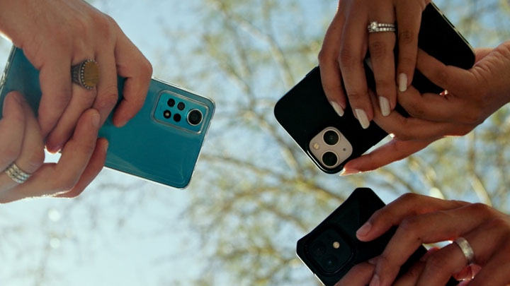 Three people holding mobile phones.